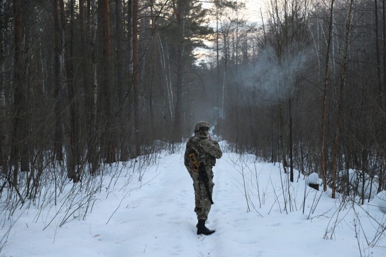 Airsoft Spieler mit passender Tarnung im Wald beim Outdoor-Einsatz